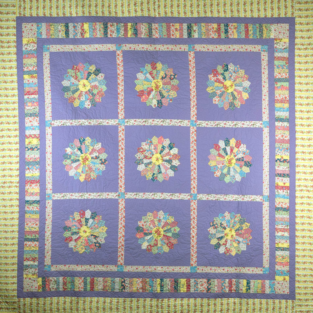Quilt with floral patterns in a grid on a purple background