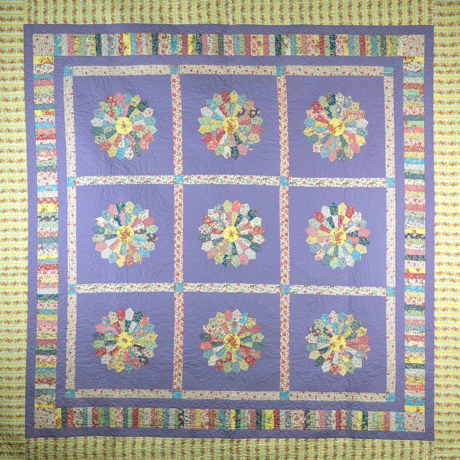 Quilt with floral patterns in a grid on a purple background