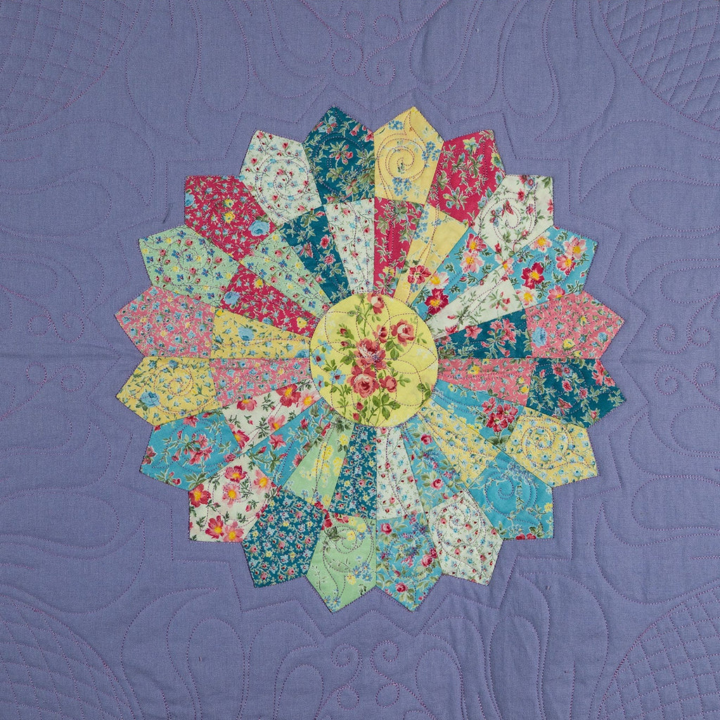 Quilt with floral patterned blocks on a purple background