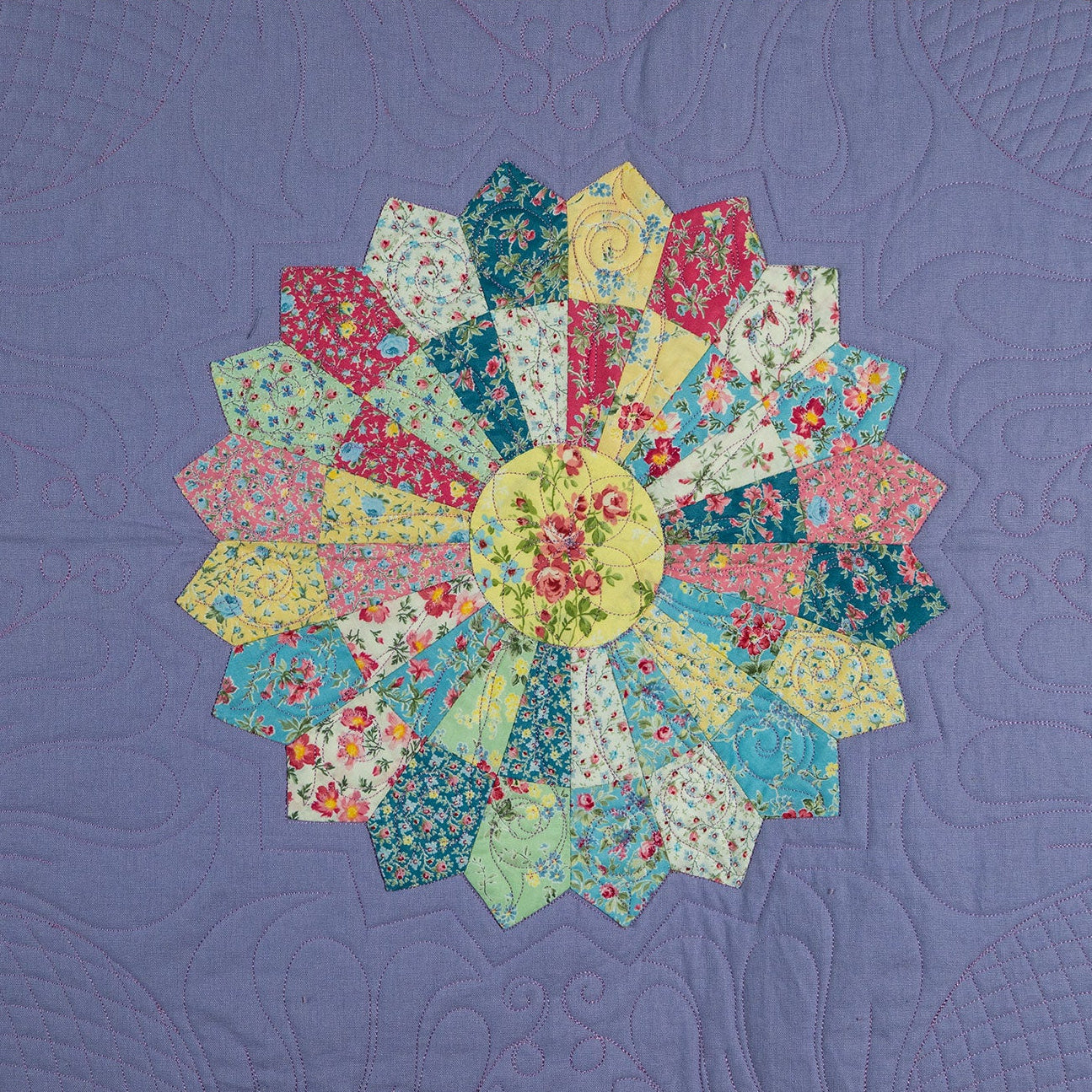 Quilt with floral patterned blocks on a purple background