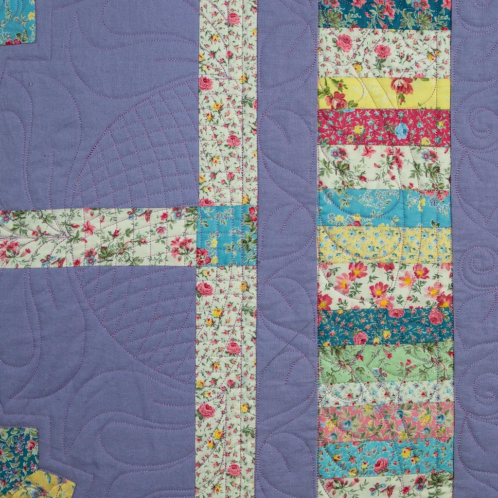 Colorful quilt with floral patterns and a purple border