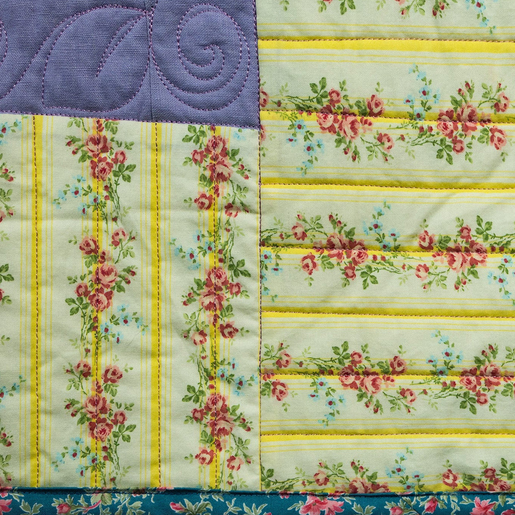 Quilt with floral and striped patterns on a white background