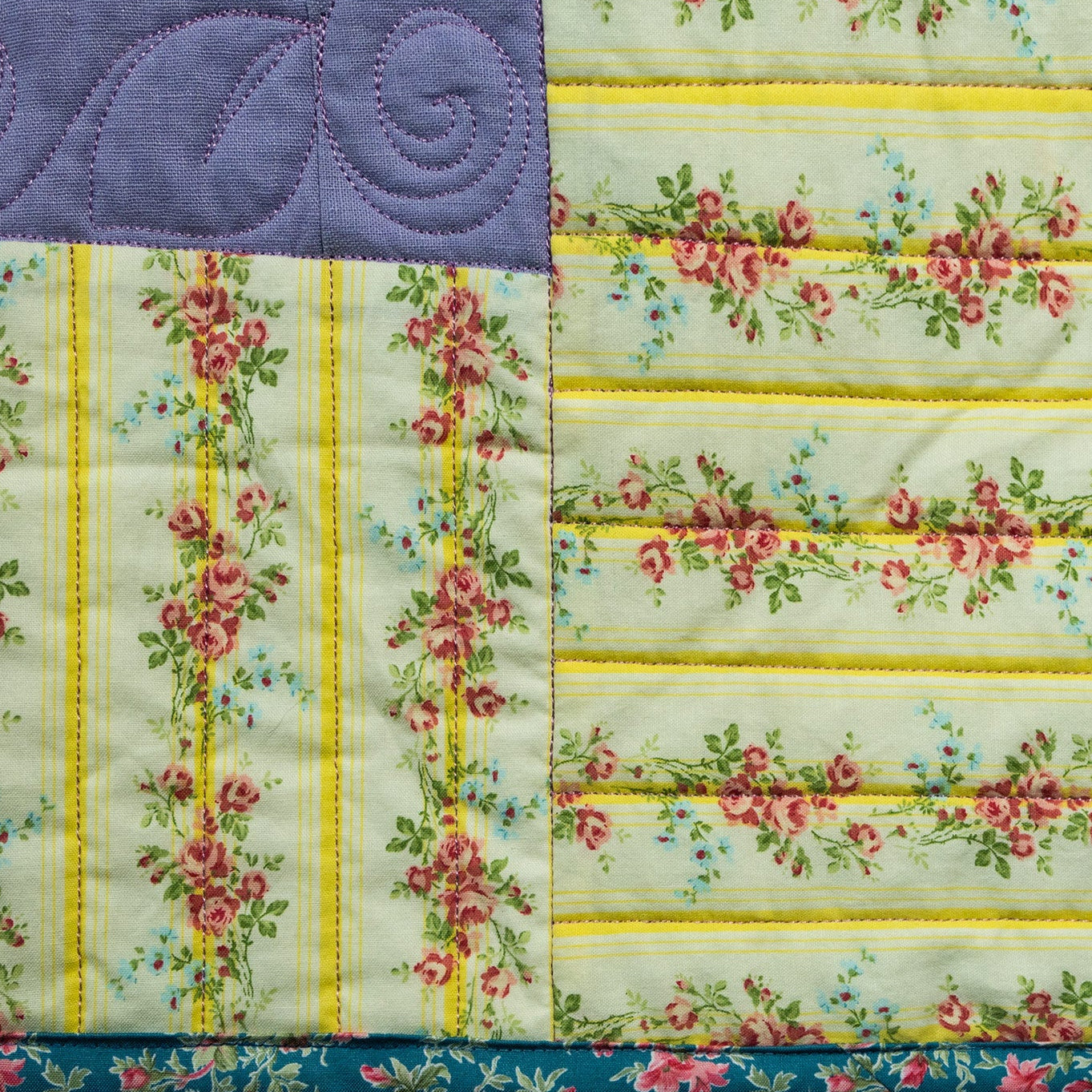 Quilt with floral and striped patterns on a white background