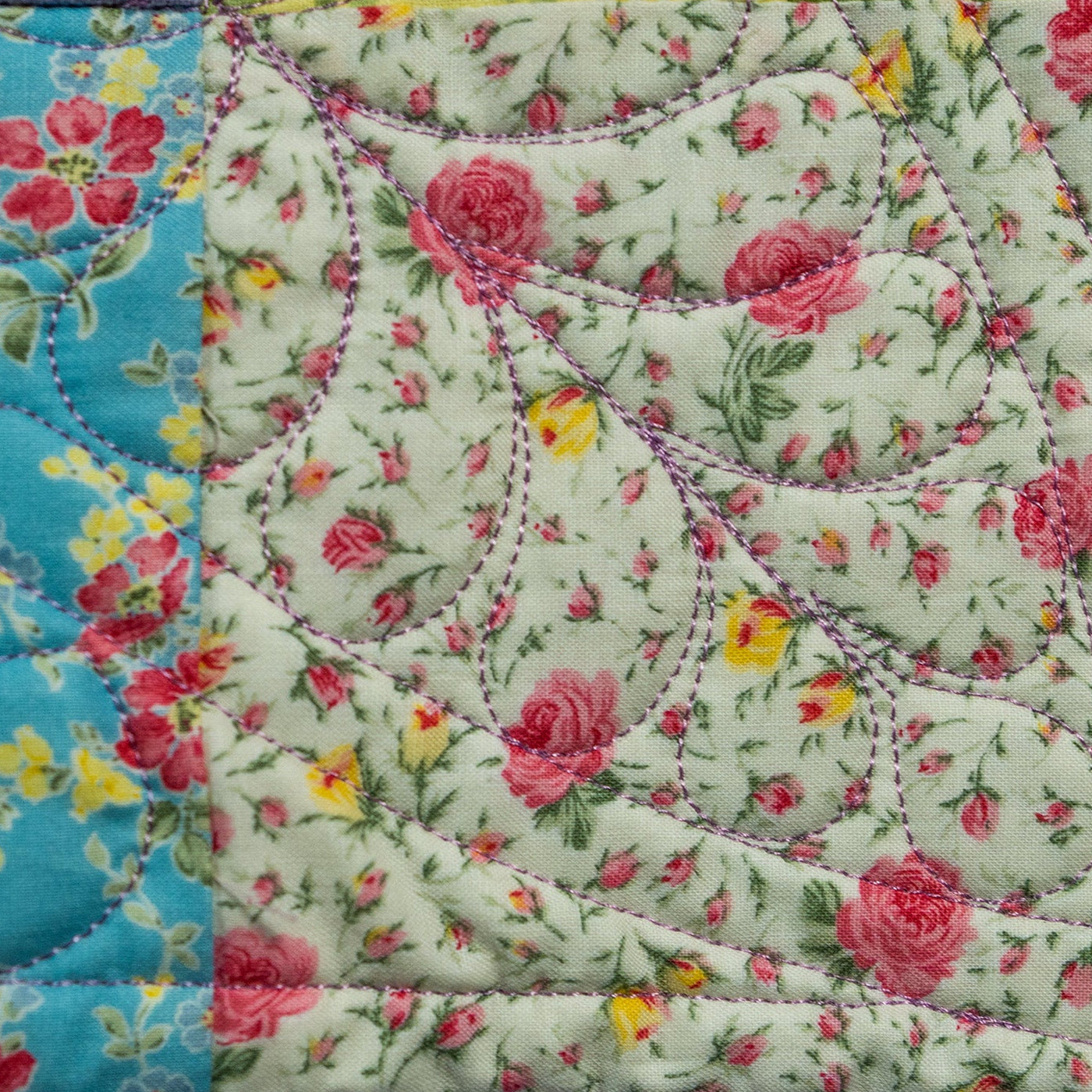 Floral quilt with pink roses and yellow flowers on a white background