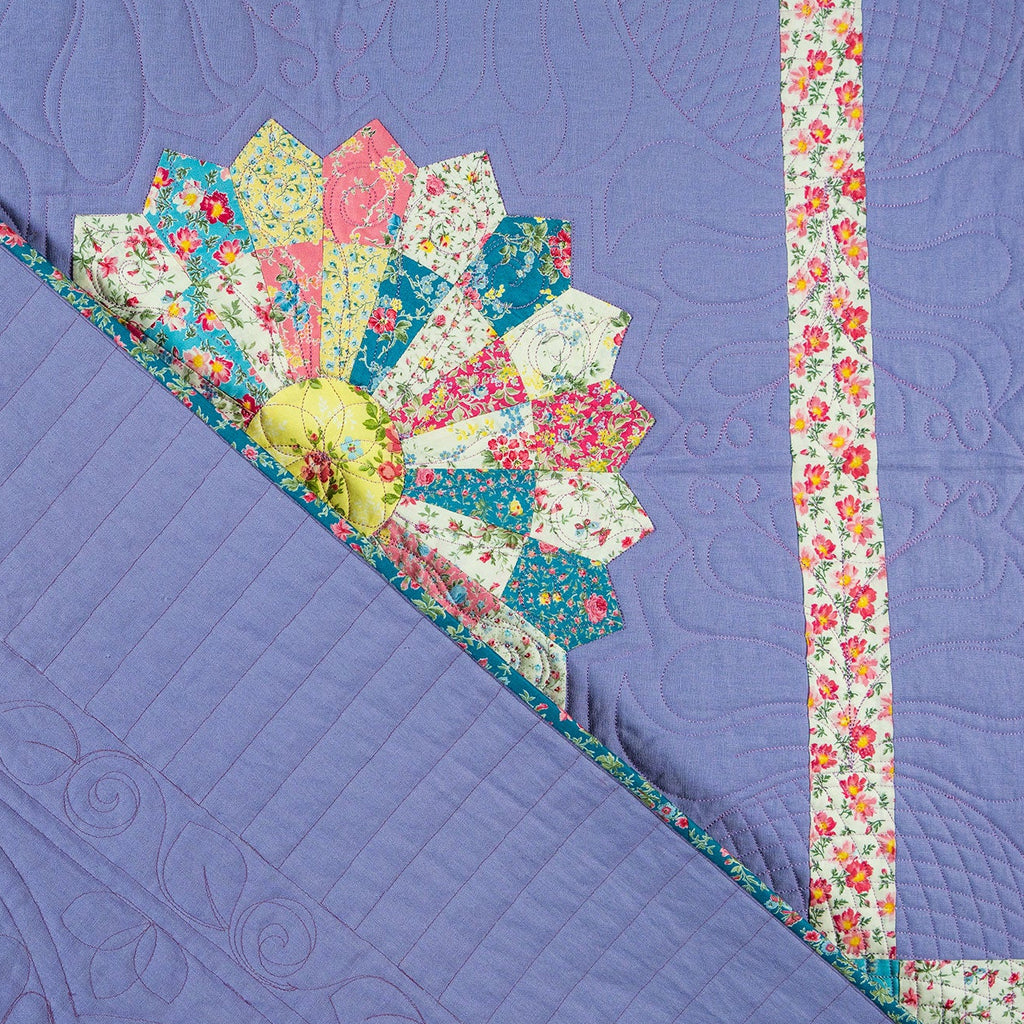 Quilt with floral border and corner on a purple background