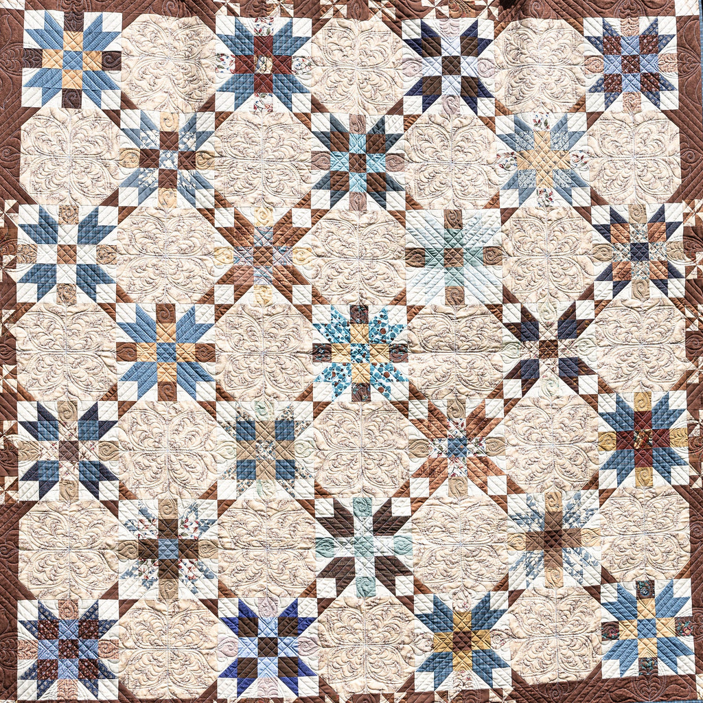 Quilt with star pattern in brown, blue, and beige.