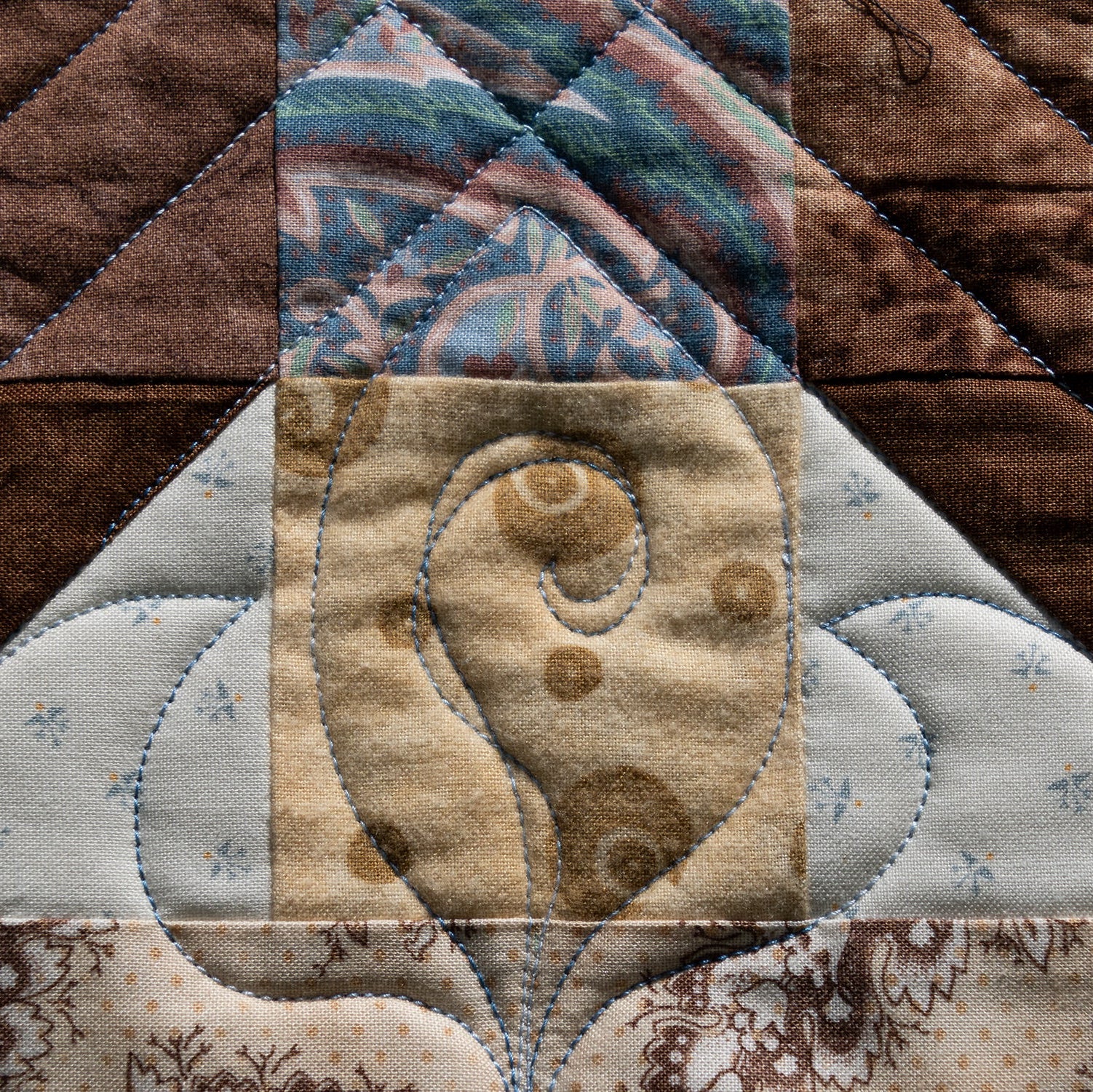 Close-up of a quilted fabric block with a floral design.
