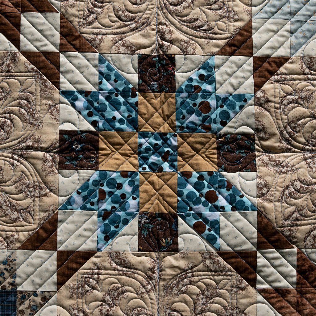 Quilt with star pattern in brown, blue, and beige colors
