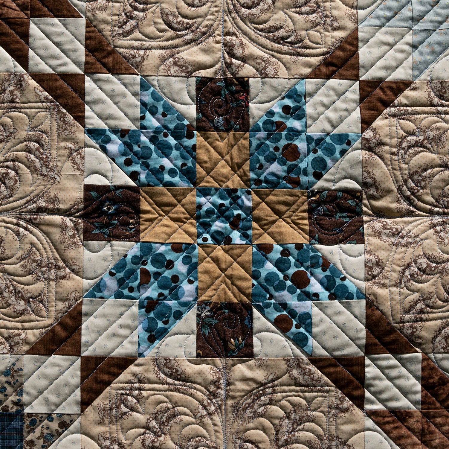 Quilt with star pattern in brown, blue, and beige colors