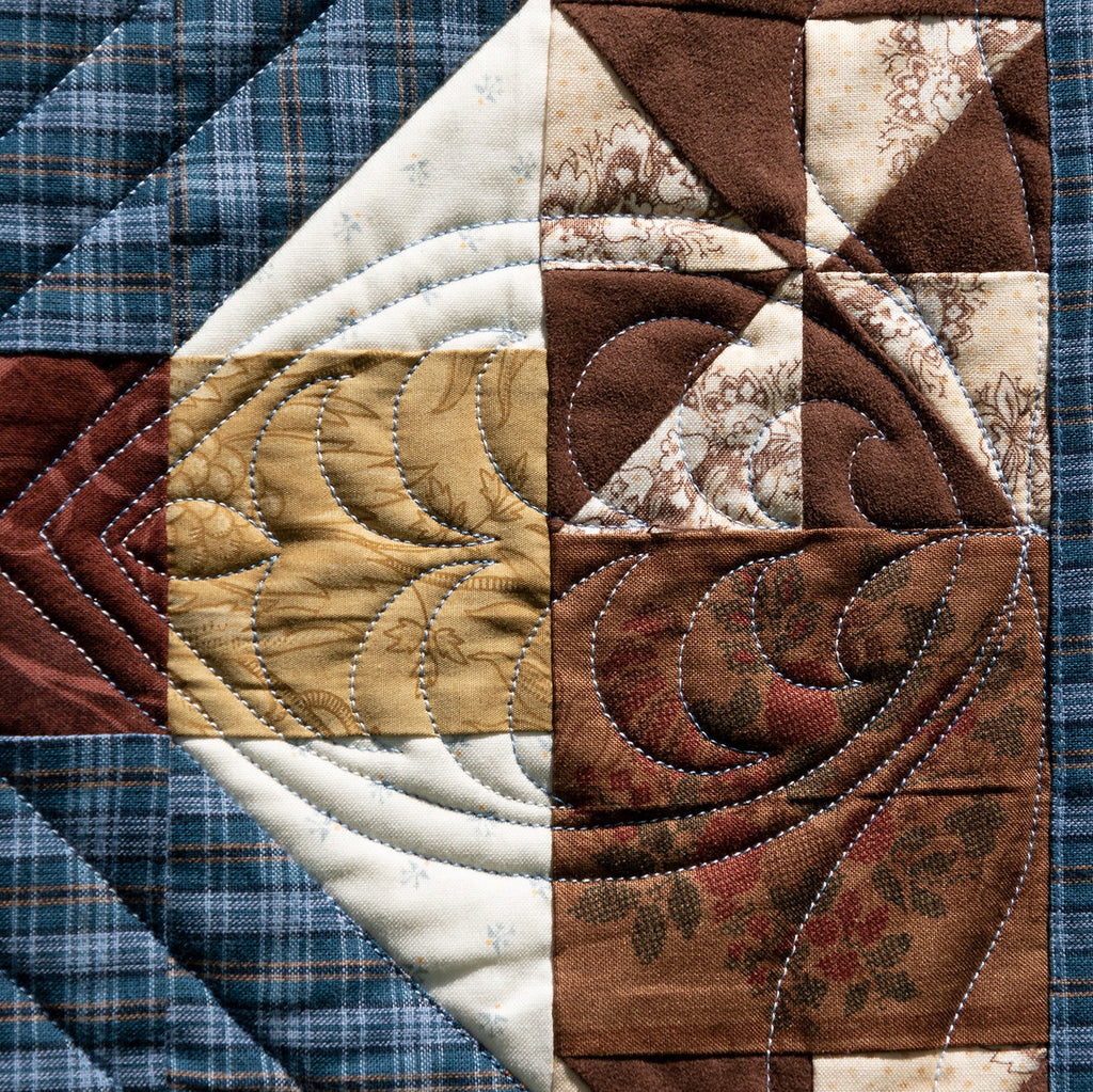 Close-up of a patchwork quilt with various fabric patterns.