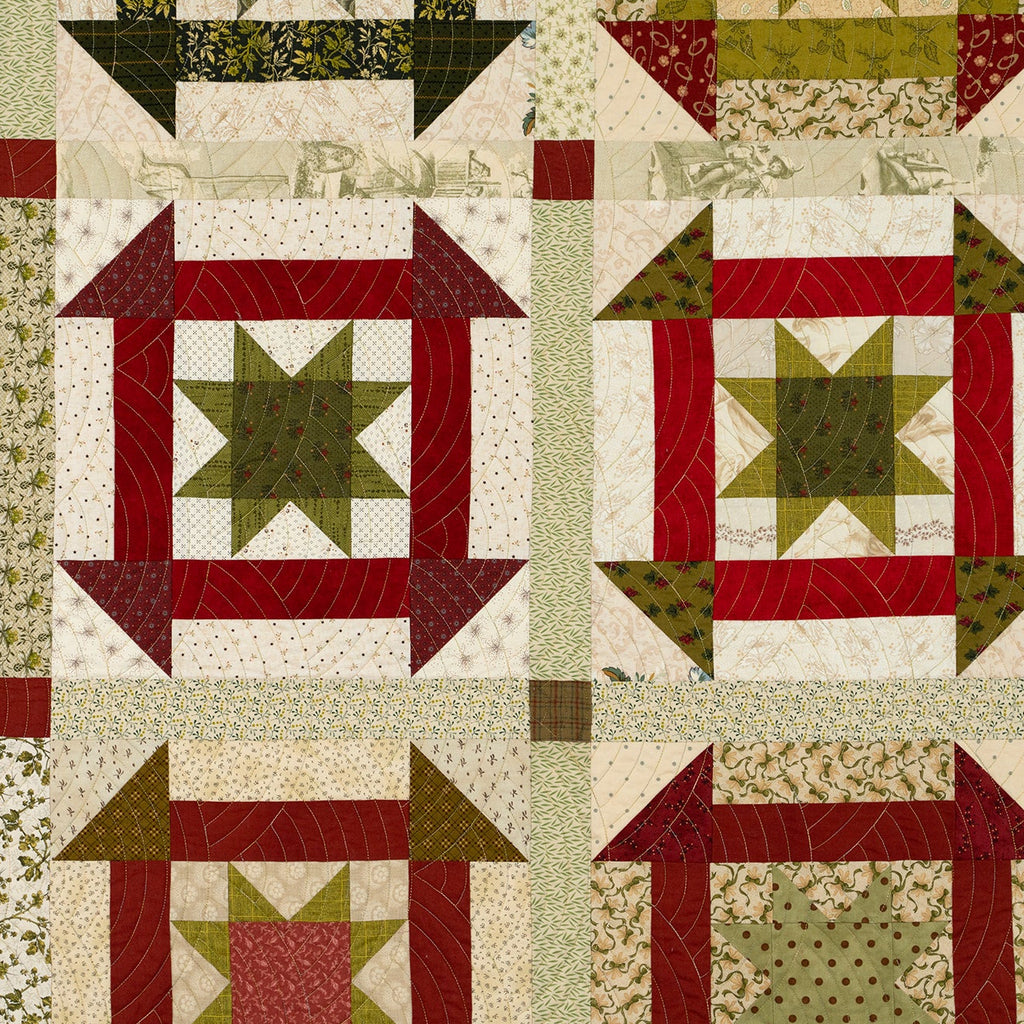 Large churn dash quilt pattern in red and green with various prints as borders