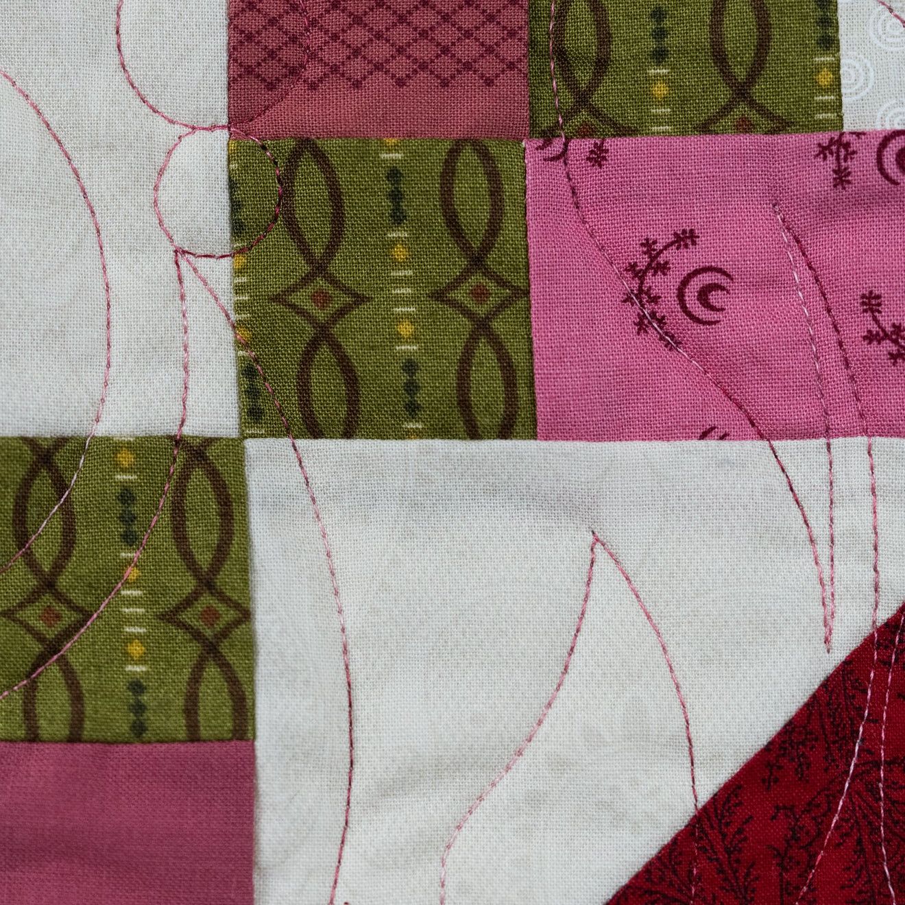 Close up detail on a quilt block in pink and green