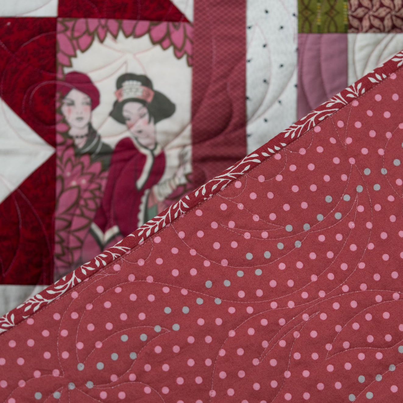 Backing of a quilt in a pink polkadot pattern with a leaf print border