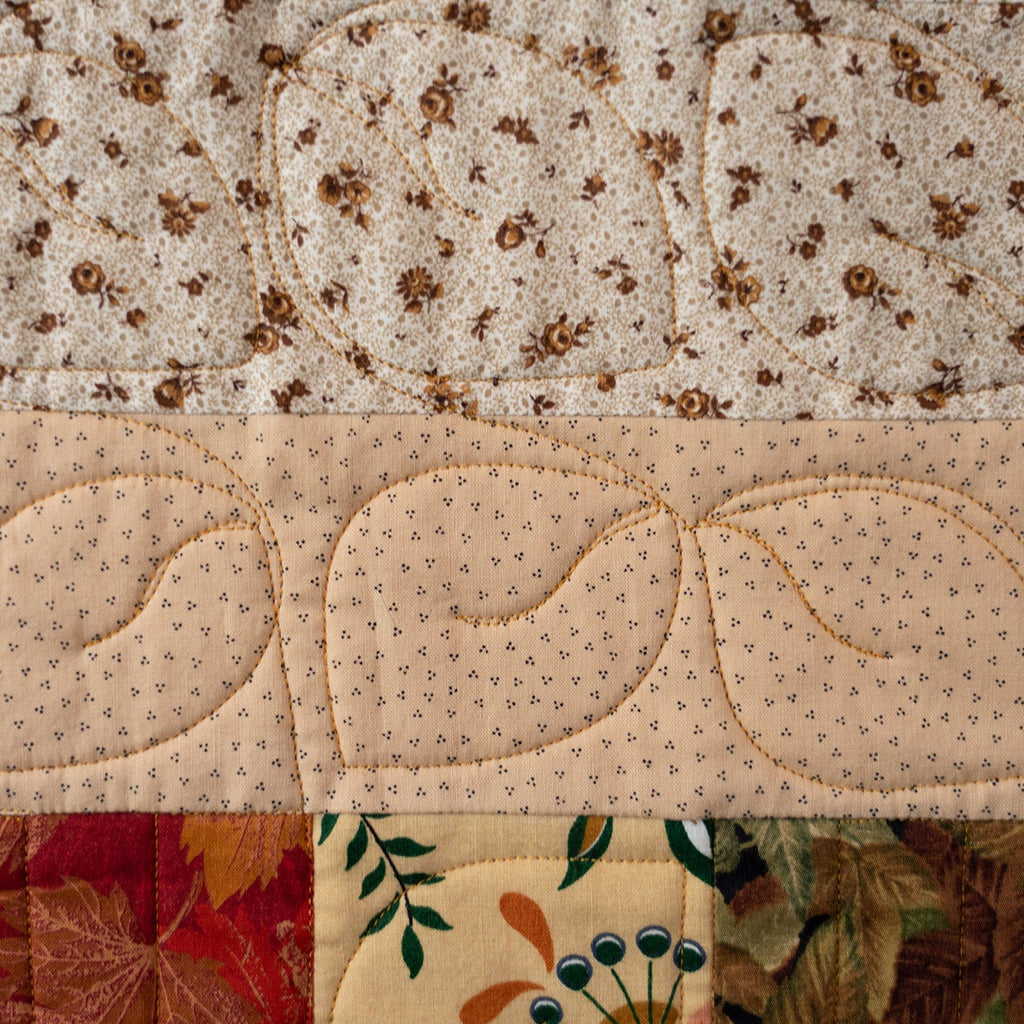 Quilt with various patterns including floral and geometric designs.