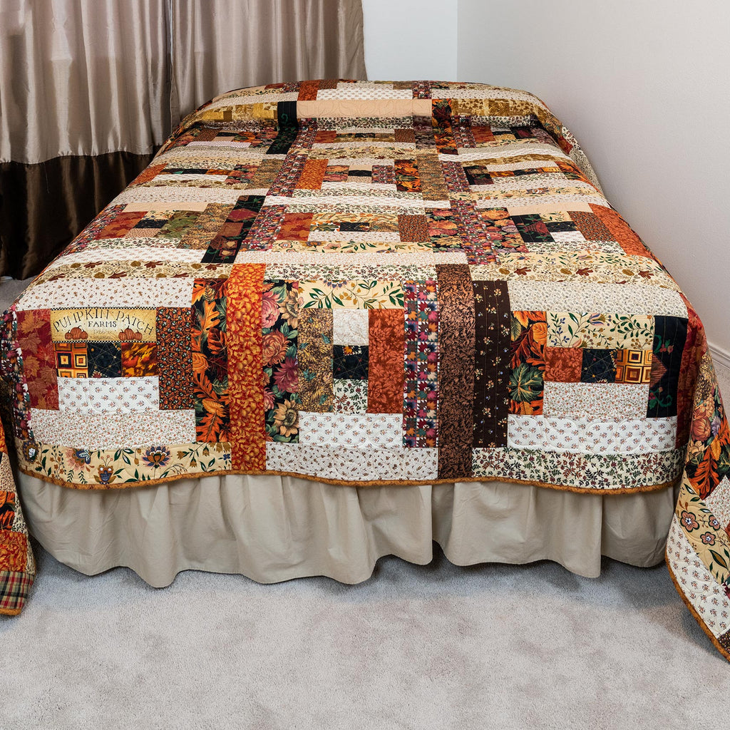 Quilted bedspread with a patchwork design on a bed in a room.