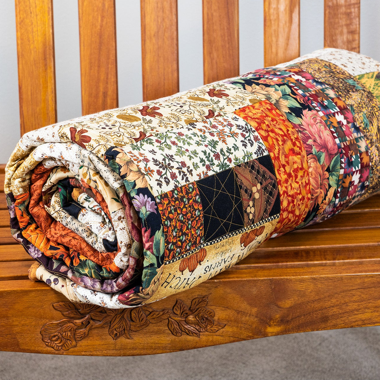 Roll of patchwork fabric on a wooden bench