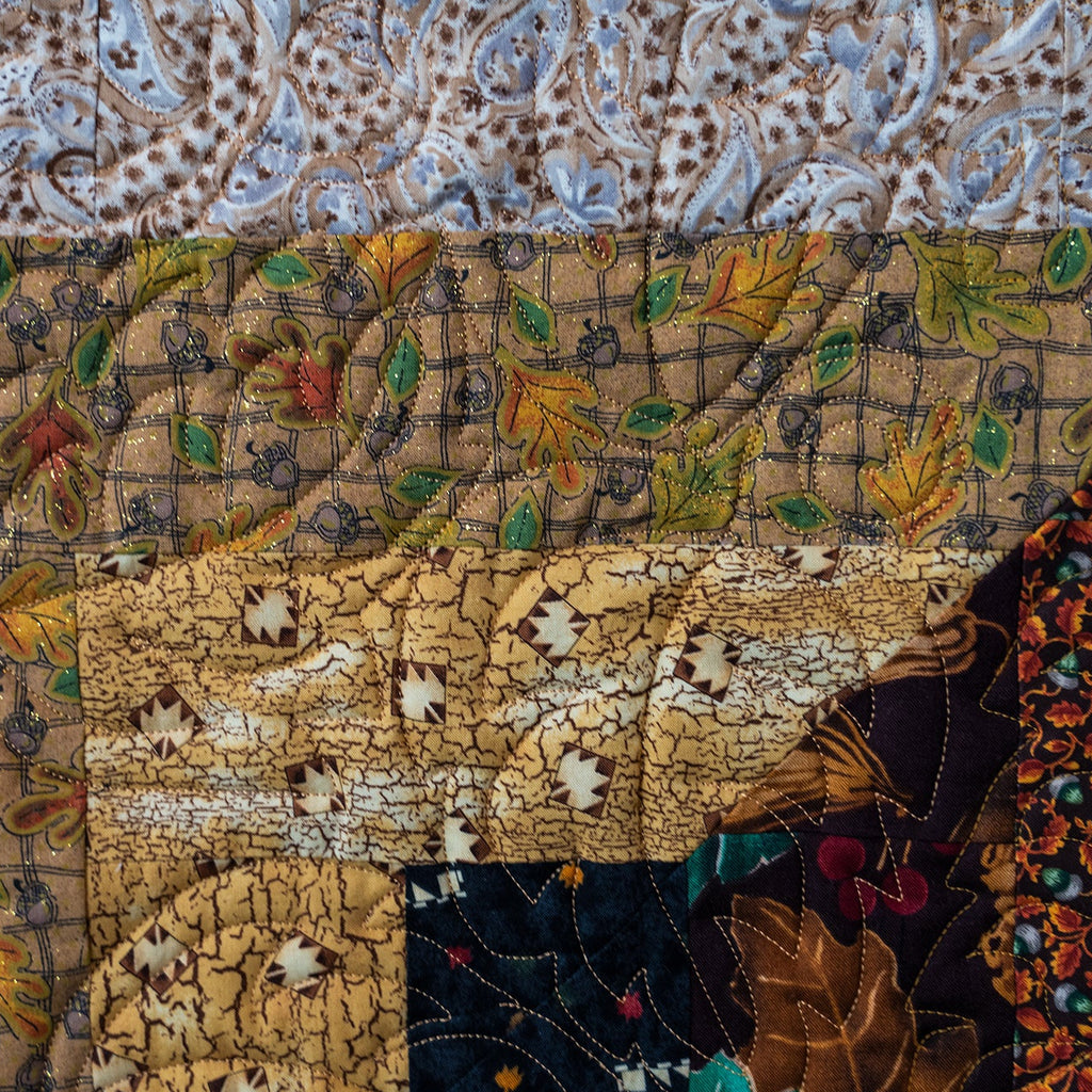 Quilt block made up of leaf prints in neutral brown colours with intricate stitch detailing.