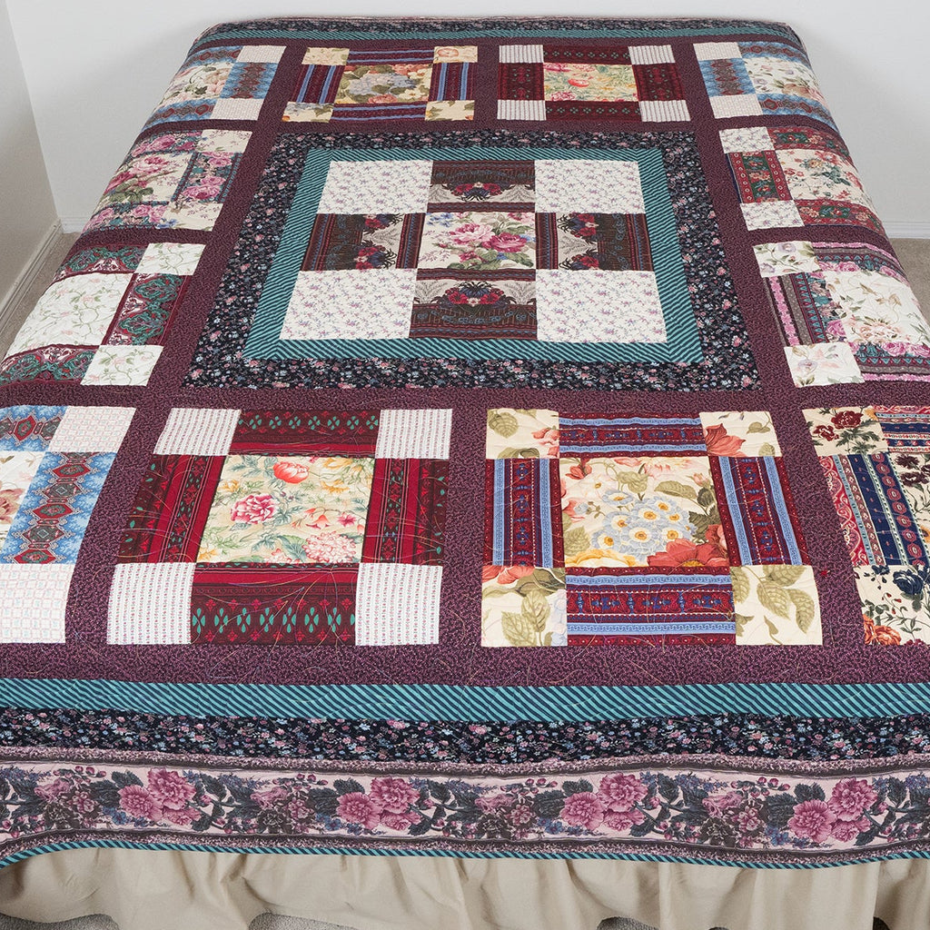 Patchwork quilt on a bed with a plain background