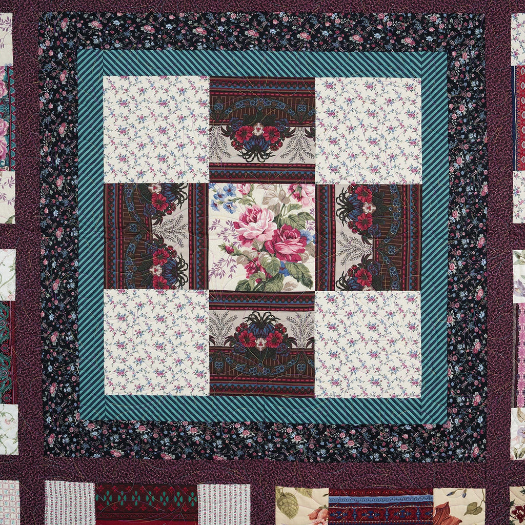 Quilt with floral and geometric patterns in a patchwork design.