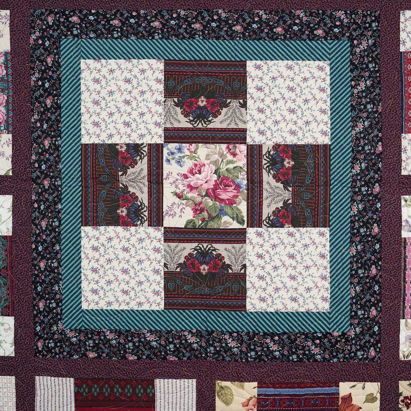 Quilt with floral and geometric patterns in a patchwork design.