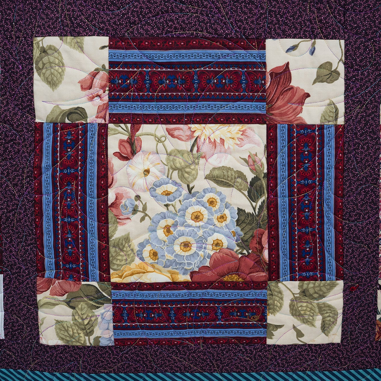 Quilt with floral and geometric patterns on a dark background
