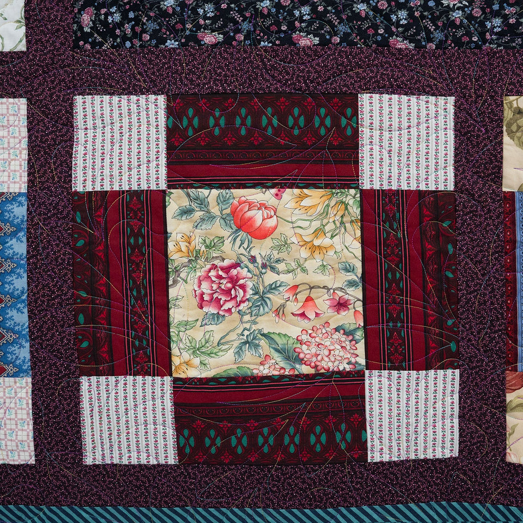 Patchwork quilt with various patterns and colors on a dark background