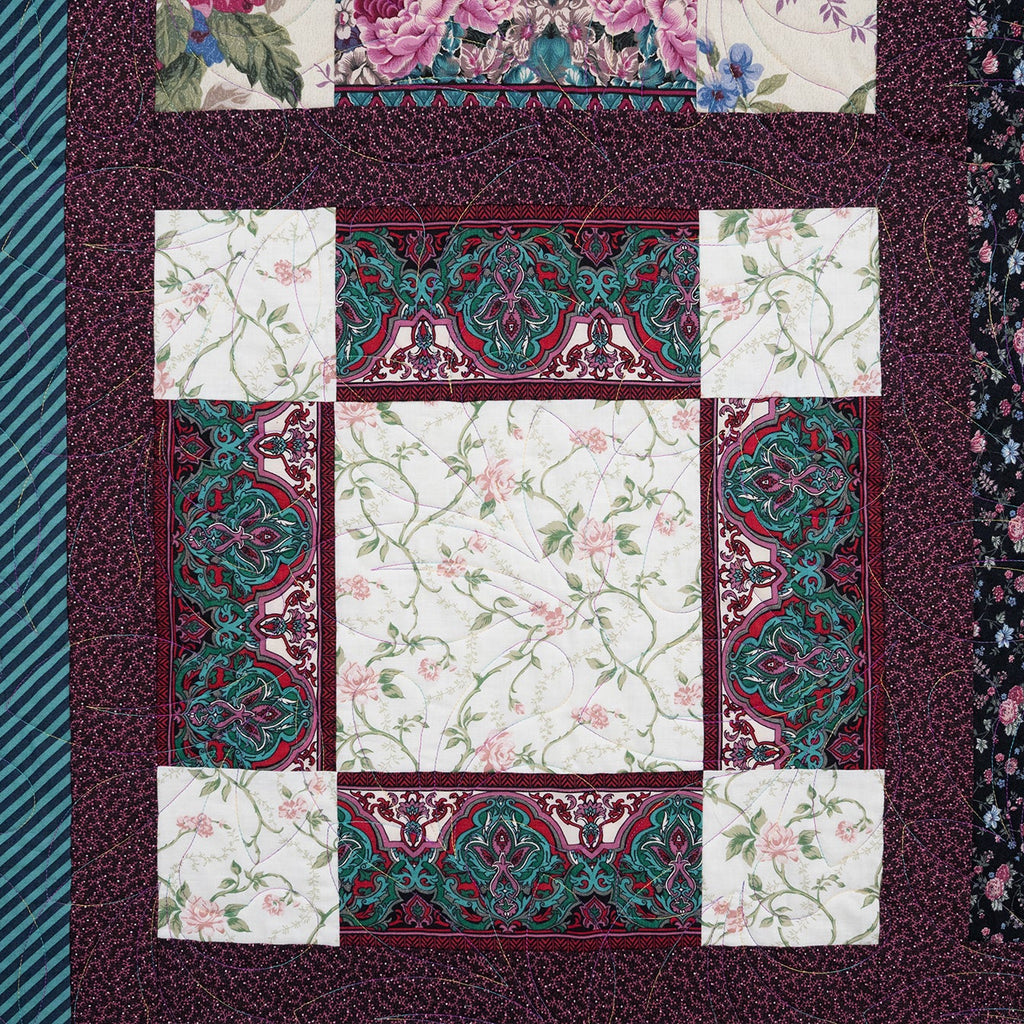 Patchwork quilt with floral and geometric patterns on a textured fabric background