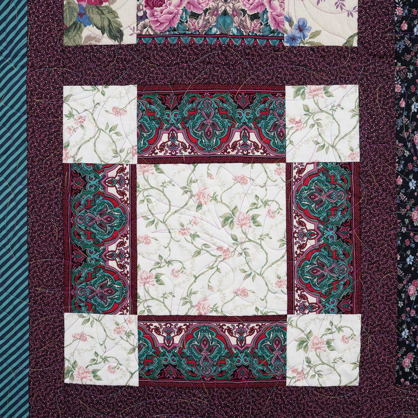 Patchwork quilt with floral and geometric patterns on a textured fabric background
