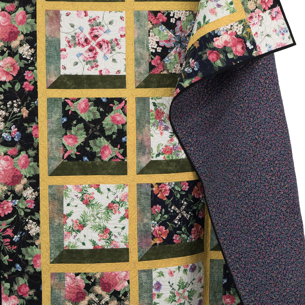 Floral quilt with a patterned border on a white background