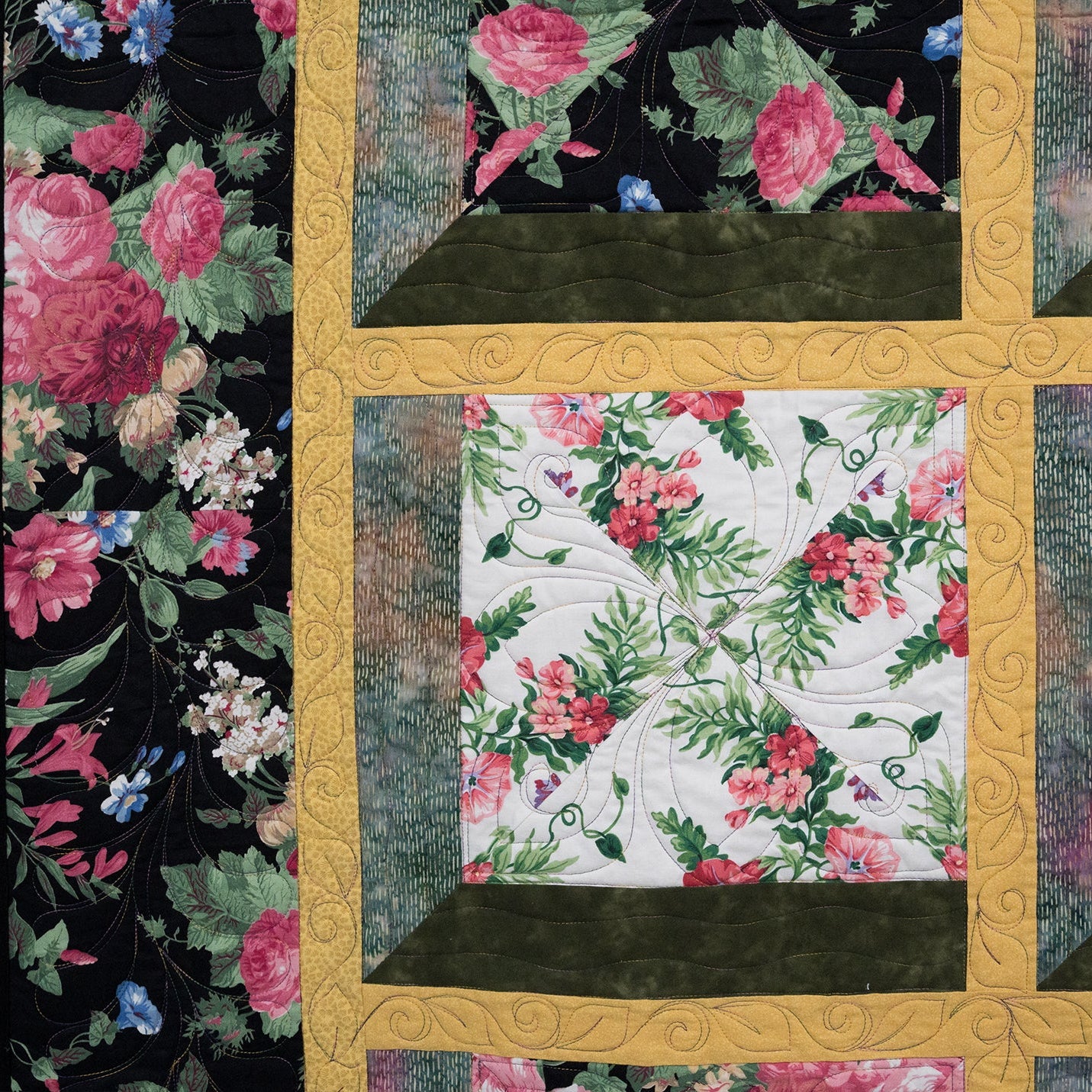 Floral quilt with a gold border featuring pink and green flowers on a black background.
