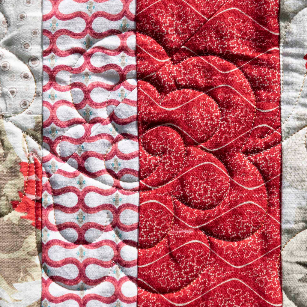 Quilt panels in red, gray, and white patterns.