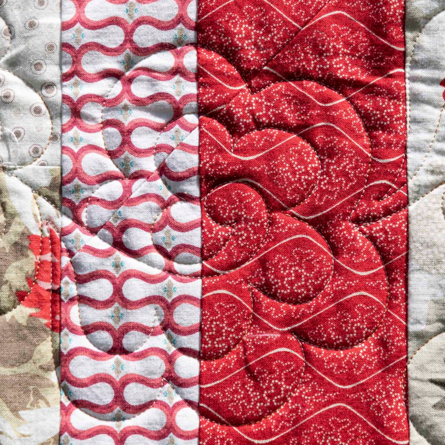 Quilt panels in red, gray, and white patterns.