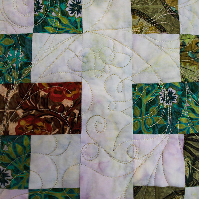 Quilt with green and brown patterns on a multicolored background