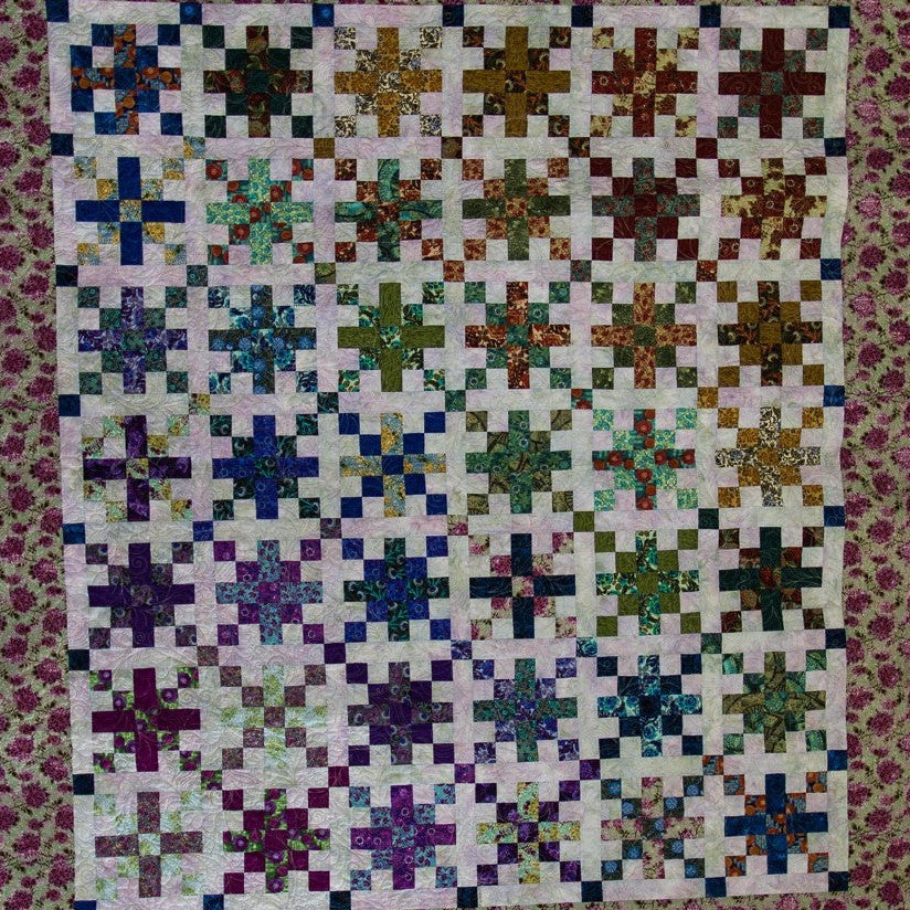 Colorful quilt with geometric pattern on a floral border