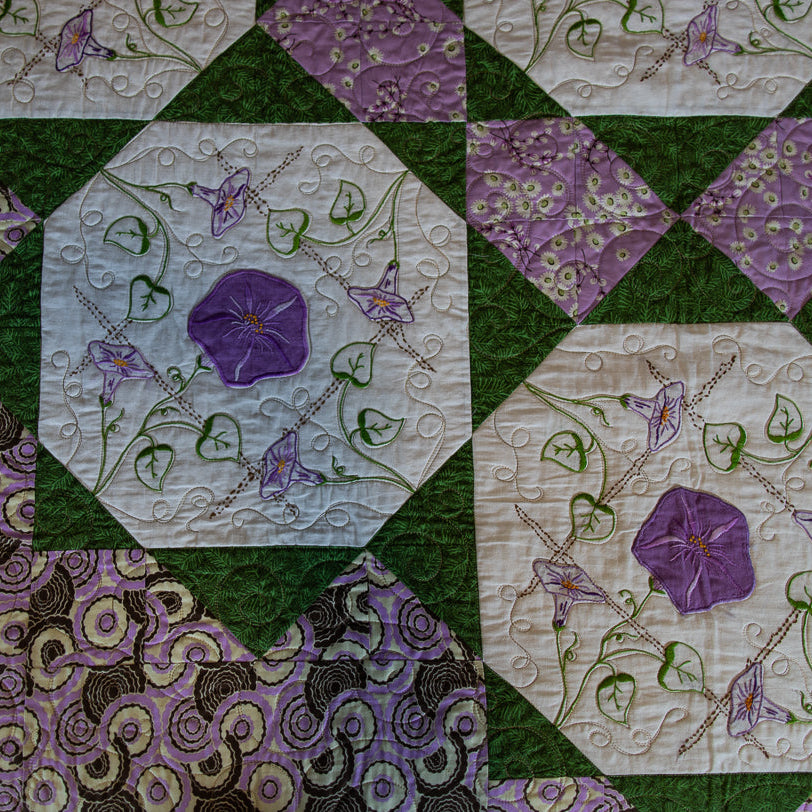 Quilt block with a floral pattern in purple and green
