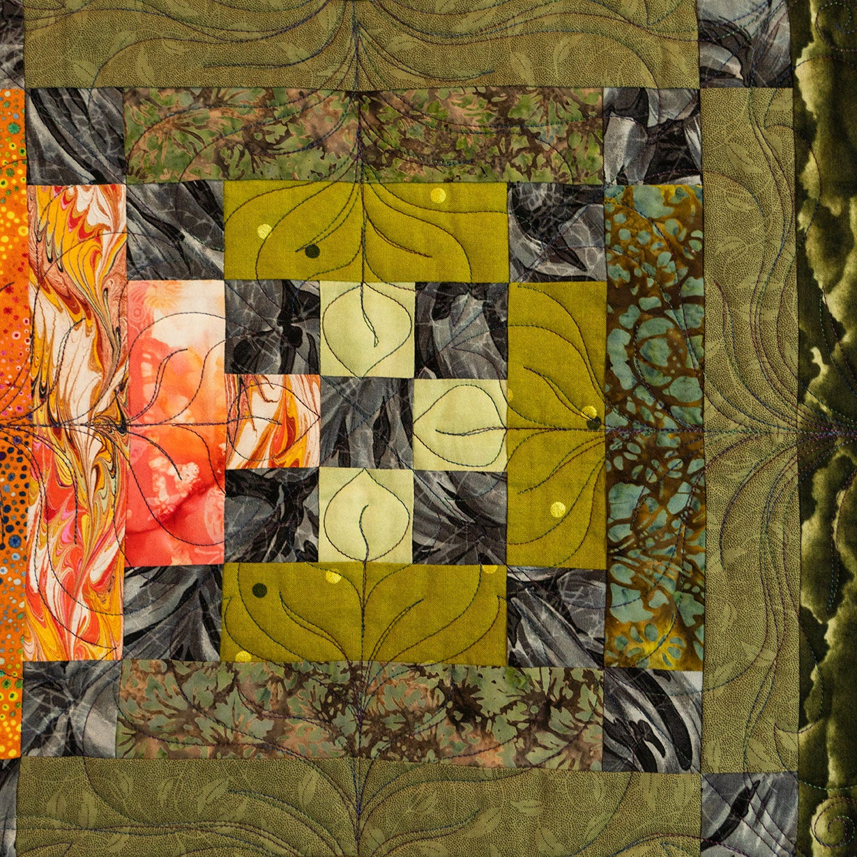Patchwork quilt with various fabric patterns in a grid layout