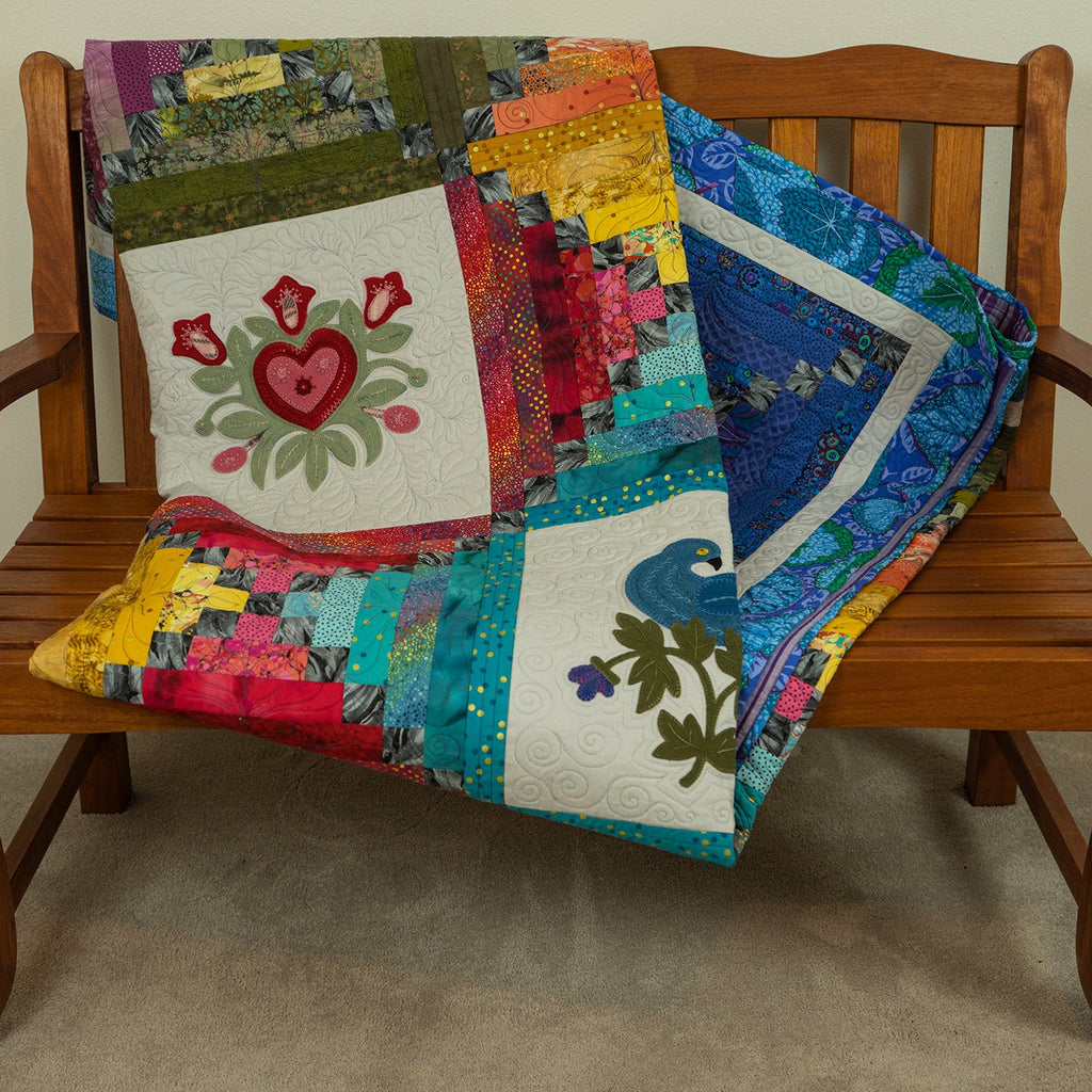 Colourful quilt folded neatly on a wooden bench