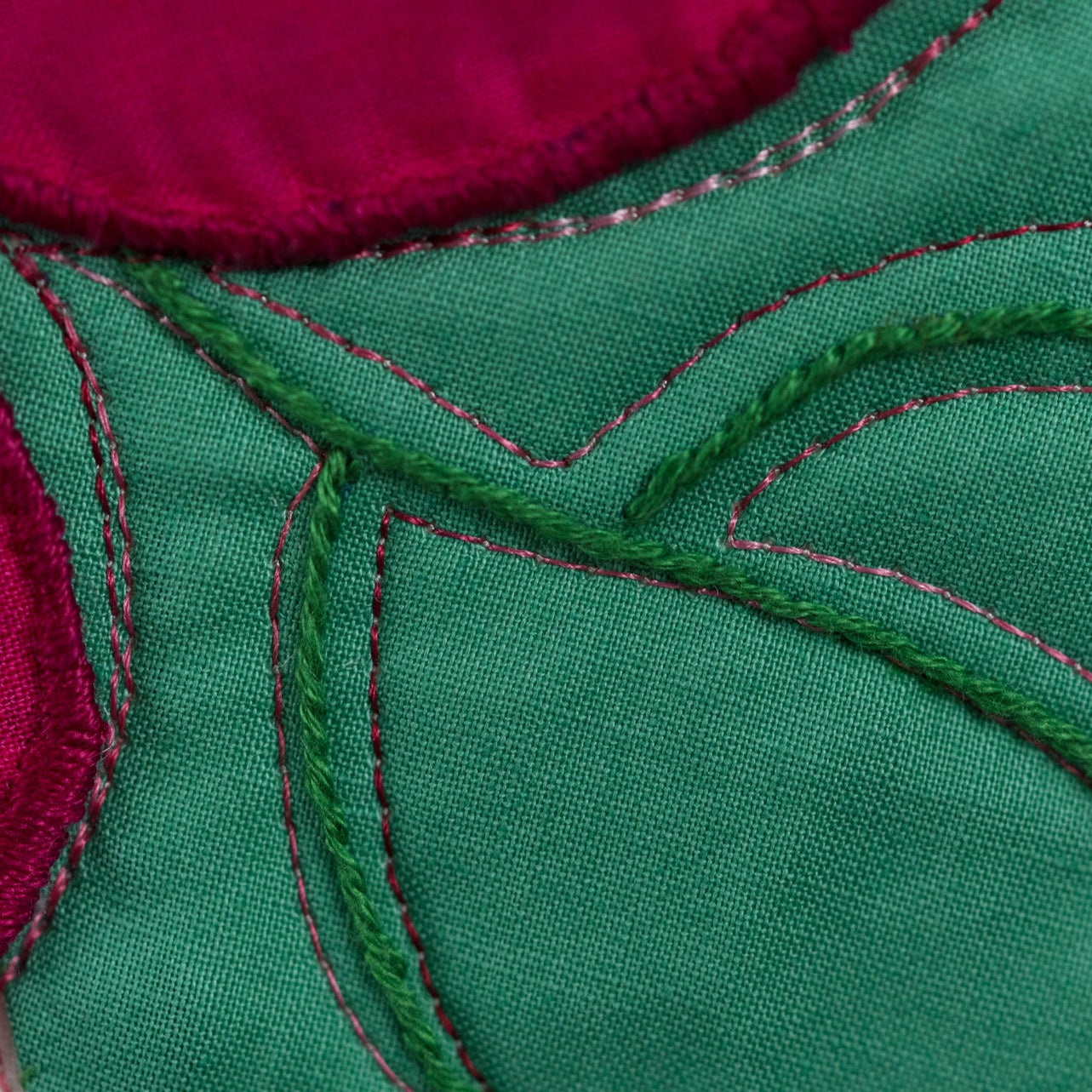 Close-up of green fabric with red stitching