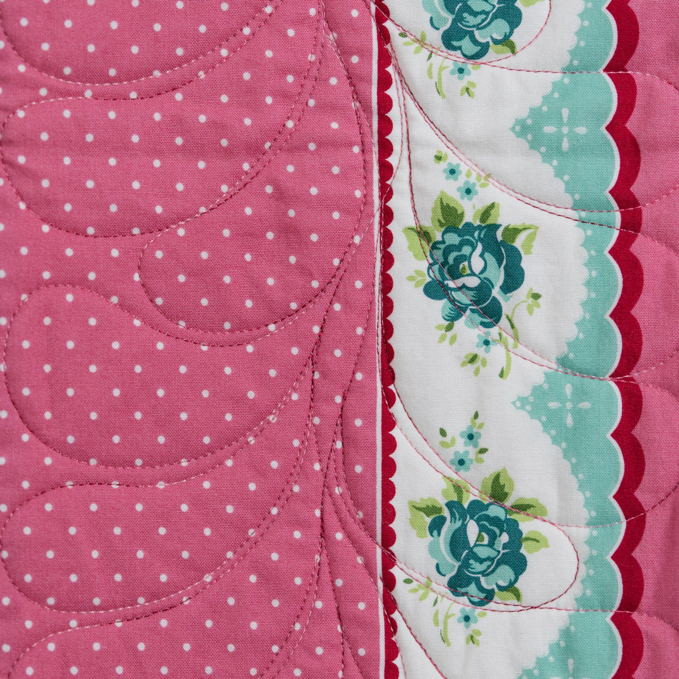 Quilt with floral and polka dot patterns on a pink background