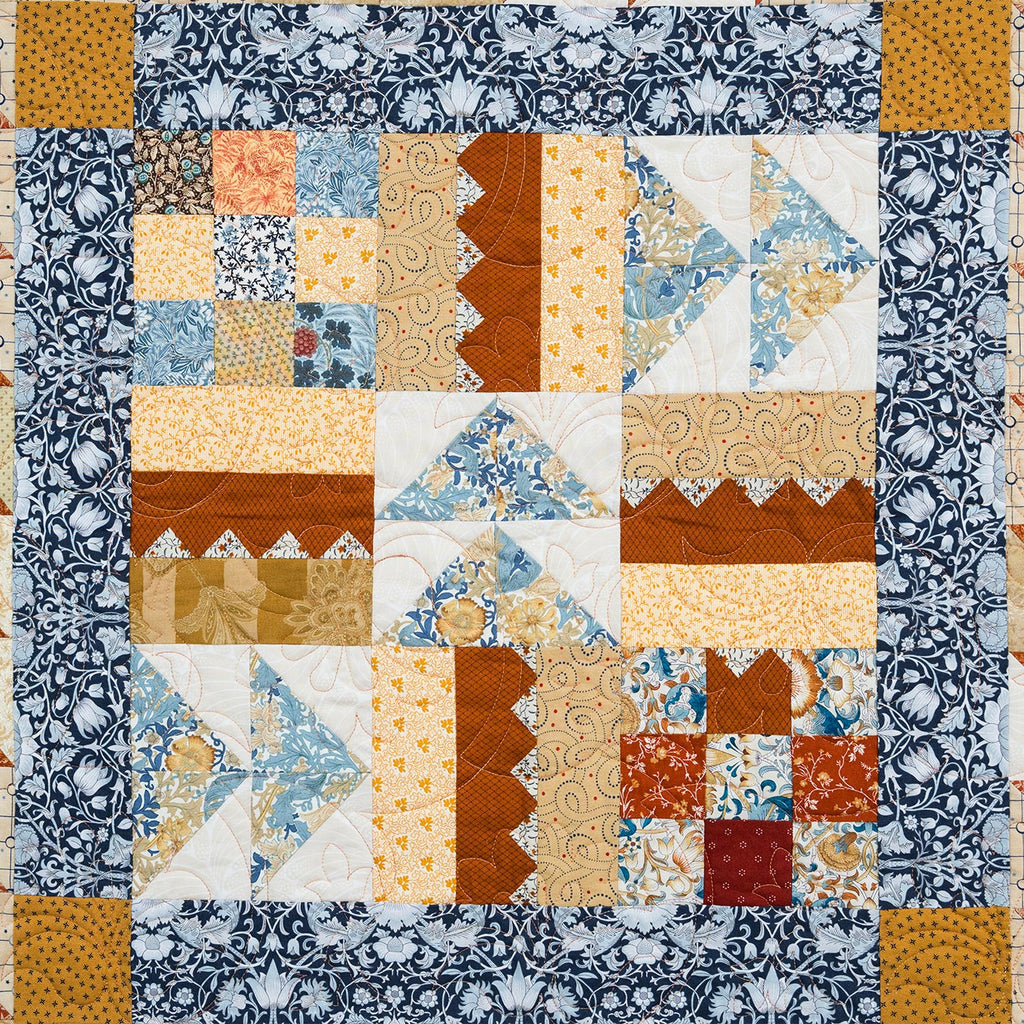 Quilt with a patchwork pattern featuring various geometric shapes and colors.