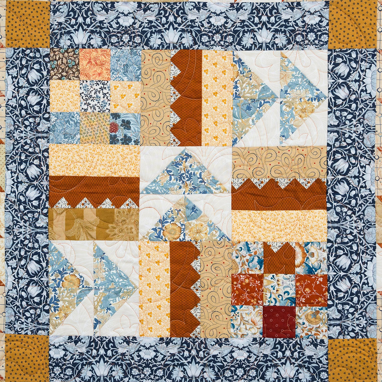 Quilt with a patchwork pattern featuring various geometric shapes and colors.