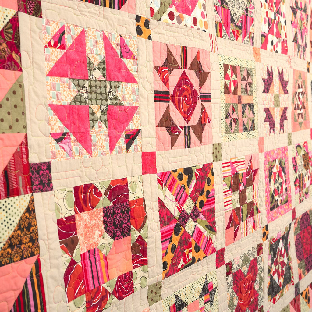 Colorful quilt with geometric patterns and floral designs.