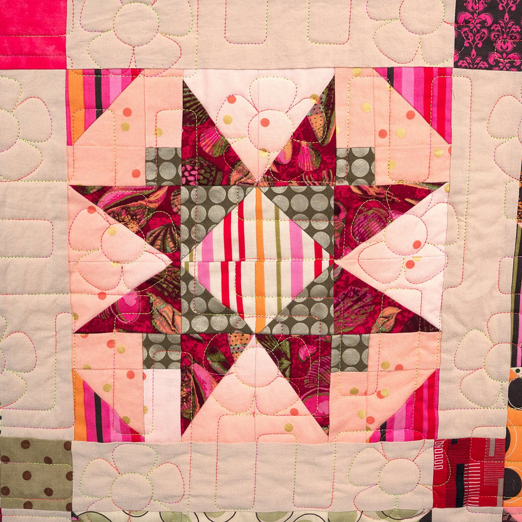 Quilt with colorful patchwork pattern featuring triangles and squares.
