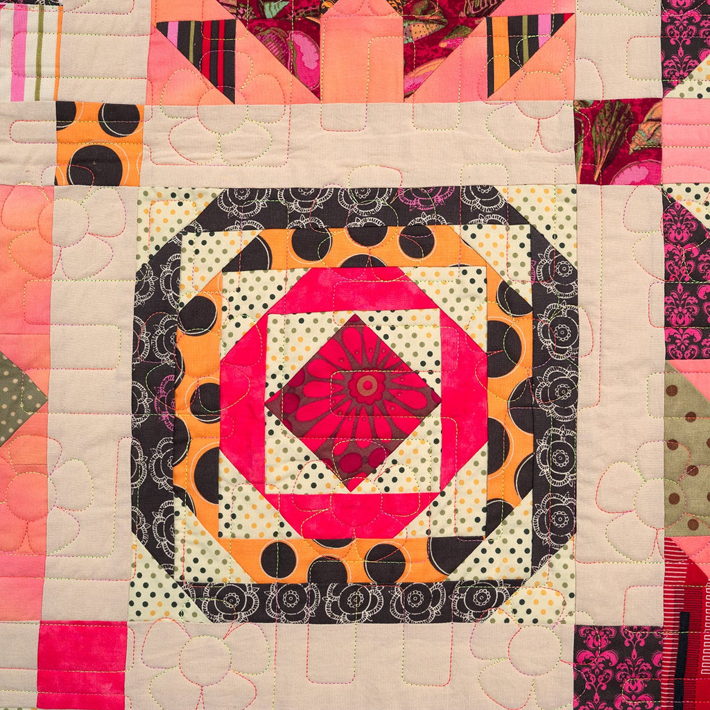 Colorful quilt with geometric patterns and a central red diamond design.