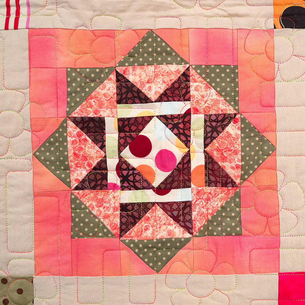 Colorful quilt with geometric patterns on a white background