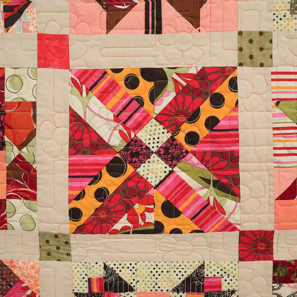 Colorful quilt with various patterns and colors on a beige background