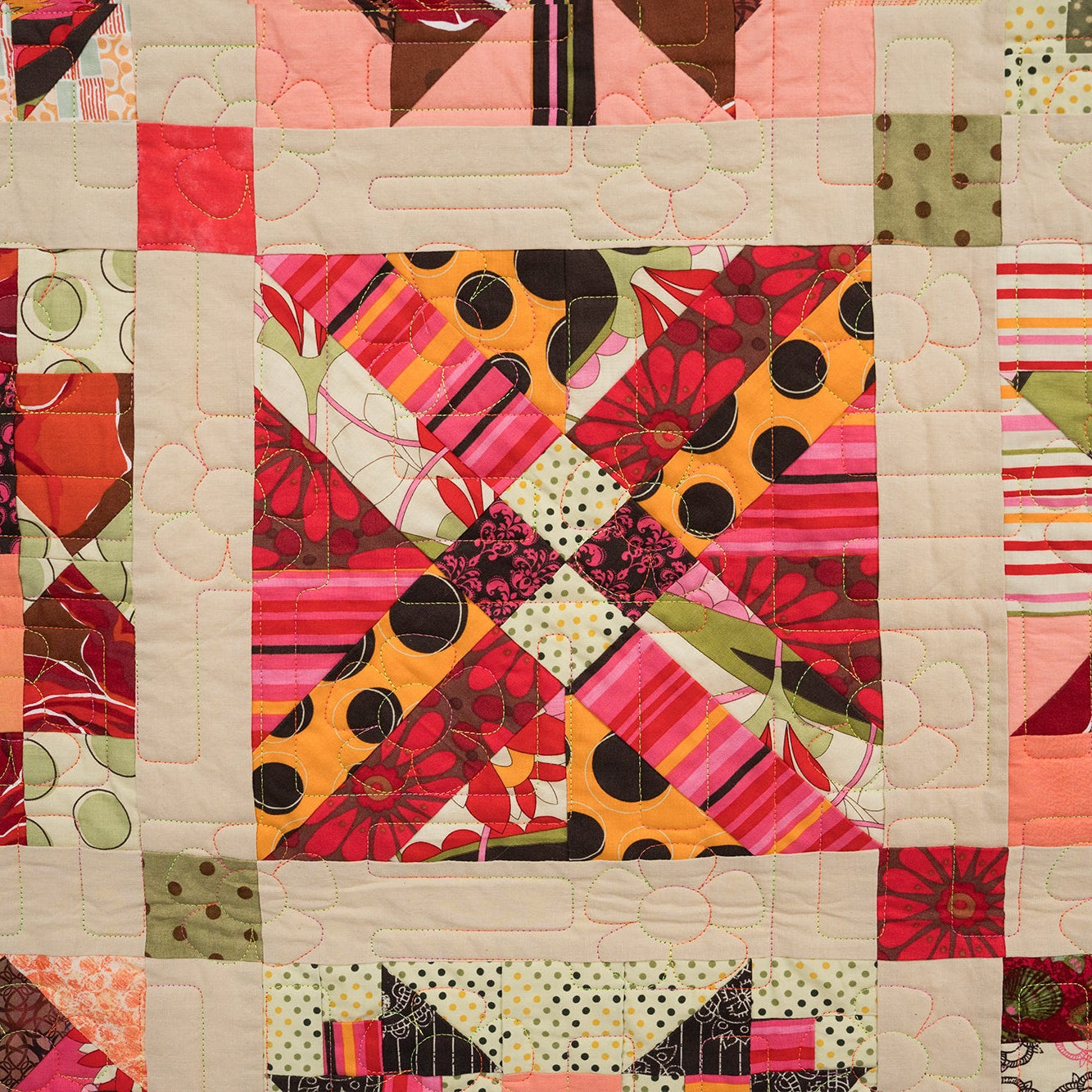 Colorful quilt with various patterns and colors on a beige background