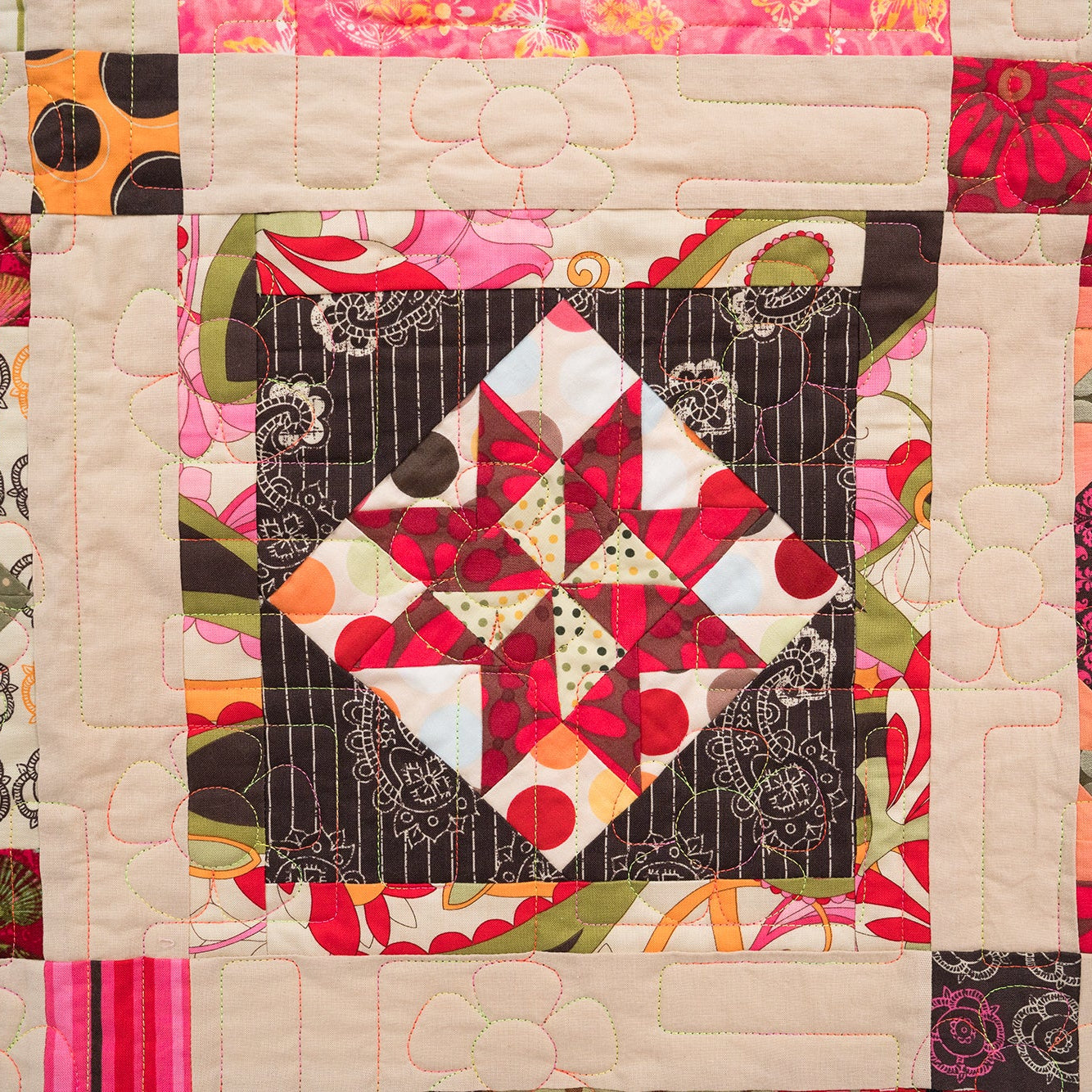 Colorful quilt with geometric patterns and floral designs.