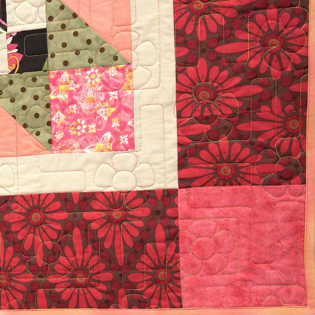 Quilt with patchwork design featuring various patterns and colors.
