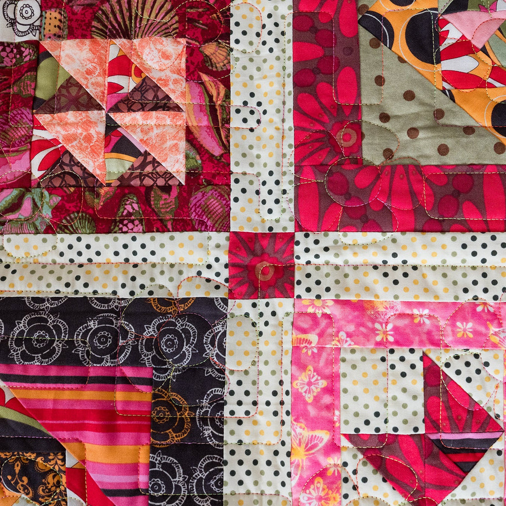 Colorful patchwork quilt with various patterns and colors.